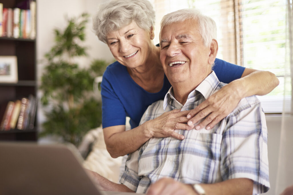 Patient centered care requires the best patient care technician. An elderly couple look at a computer and smile. 