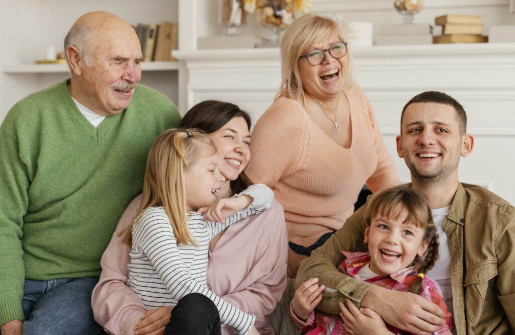 Get the ulitmate patient care technician with HealthWright medical device sales. A family sits together and laughs on the couch.