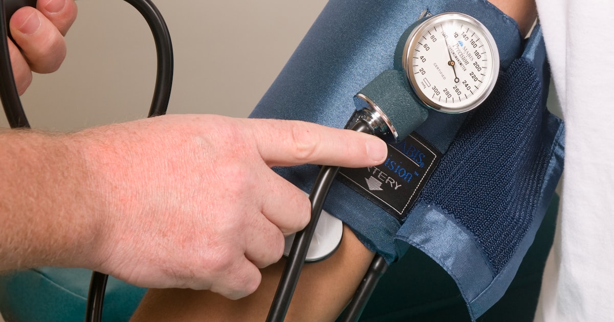 Clinician performing a cuff-based pulse volume recording assessment in an independent medical practice