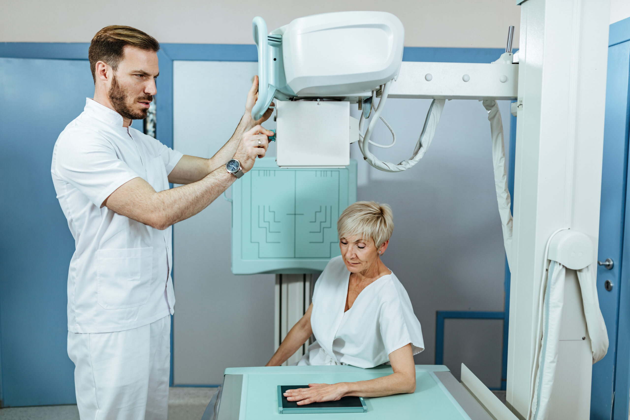 Clinician performing extremity fluoroscopy under the mini C-arm requirements that apply in a physician office
