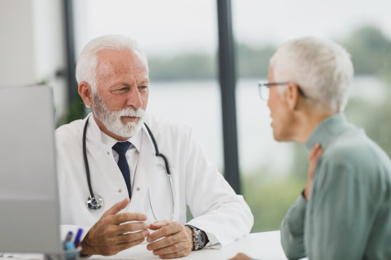 Physician reviewing vascular testing for pain management with an older adult patient at an independent practice